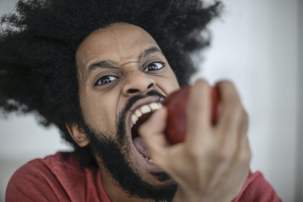 Man in Red Shirt Holding Red Apple