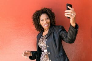 Woman in Black Leather Jacket Holding Black Smartphone